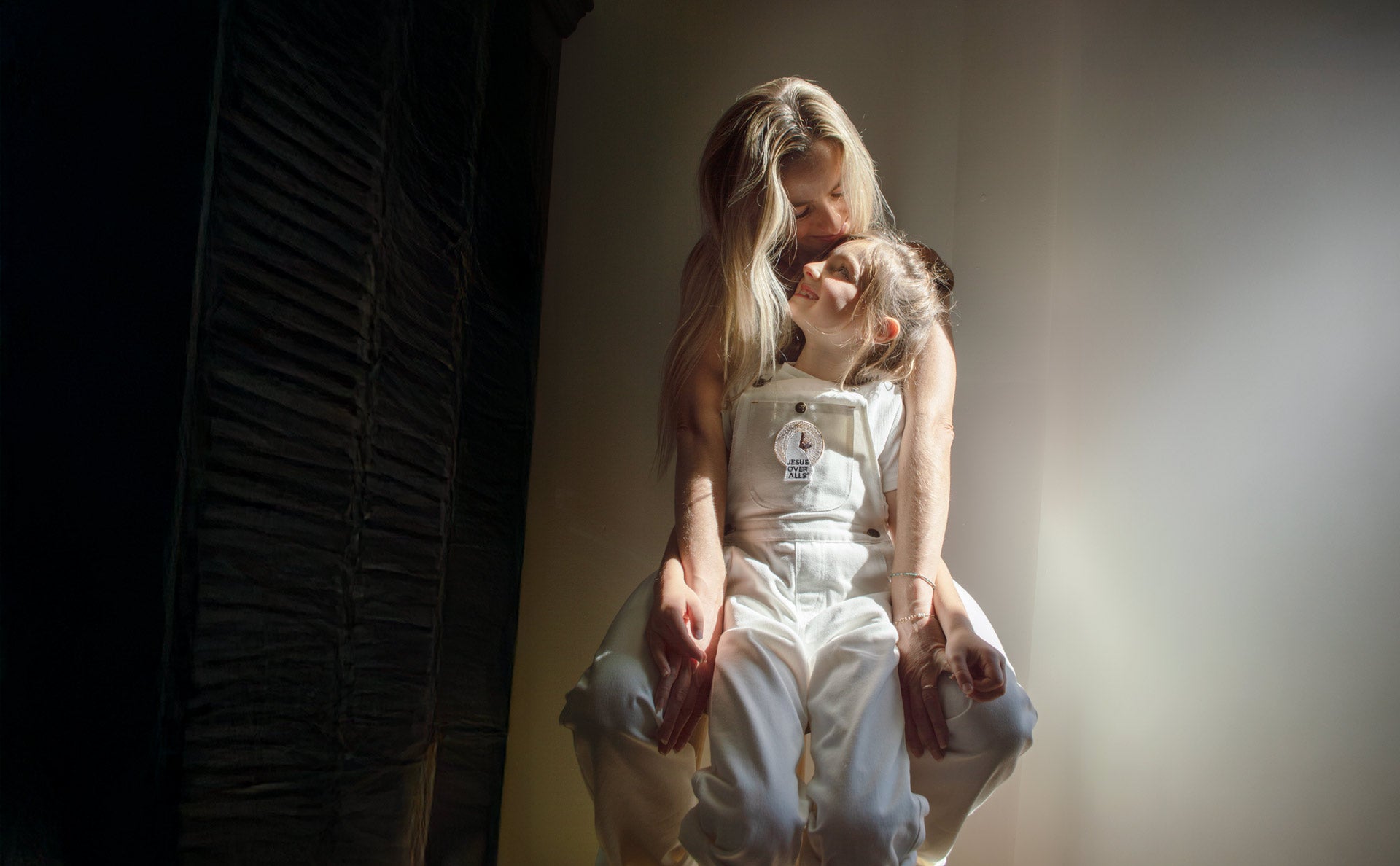 Mom and daughter on a stool with white Jesus overalls